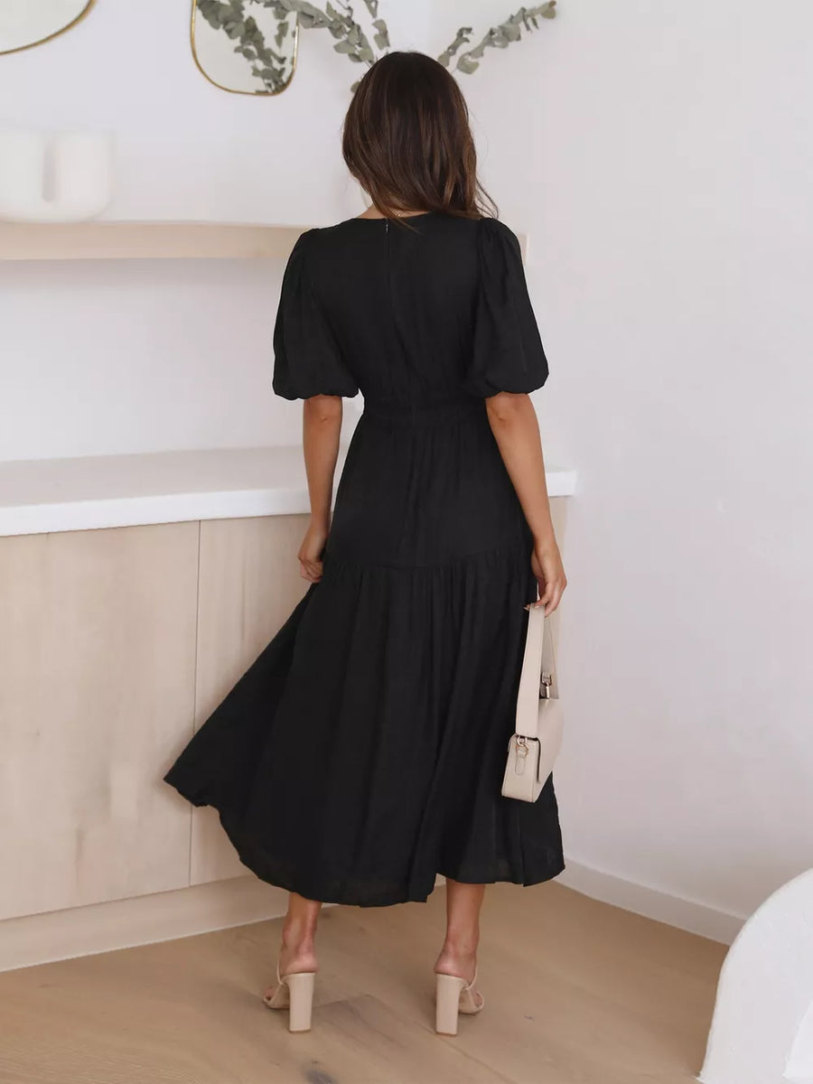 Black puff sleeve midi dress with tiered skirt and cinched waist.