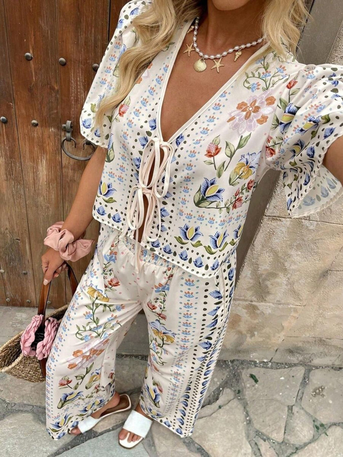 Floral tie-front cropped top and wide-leg pants set with flutter sleeves.
