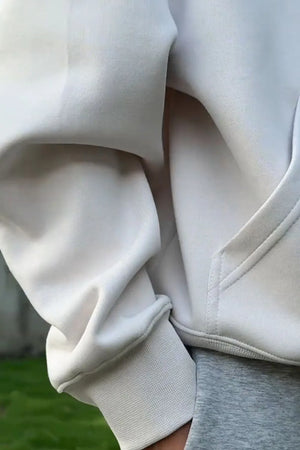 Light gray oversized slouch hoodie with kangaroo pocket and ribbed cuffs.