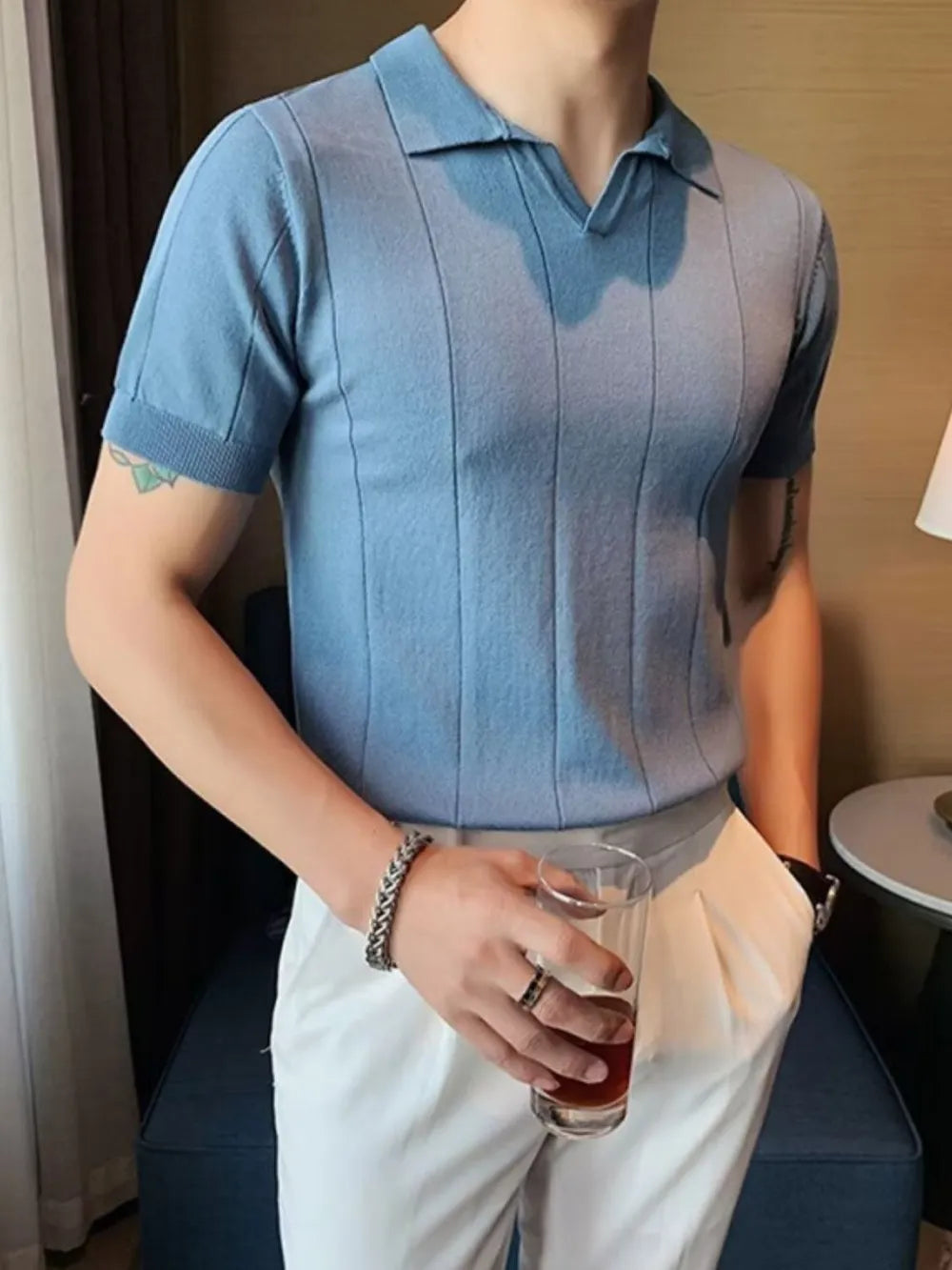 Dusty blue knit polo shirt with vertical ribbing and short sleeves.