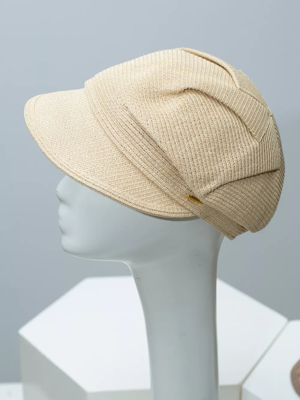 Beige woven newsboy cap with a textured weave and a decorative band detail.