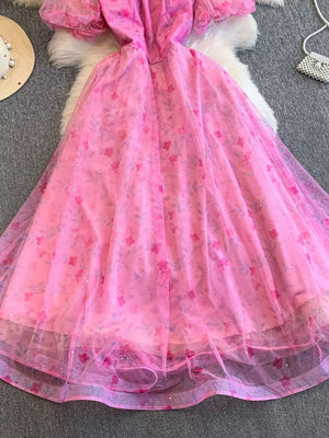 Pink floral maxi dress with puff sleeves and a sweetheart neckline, featuring lace embellishments.