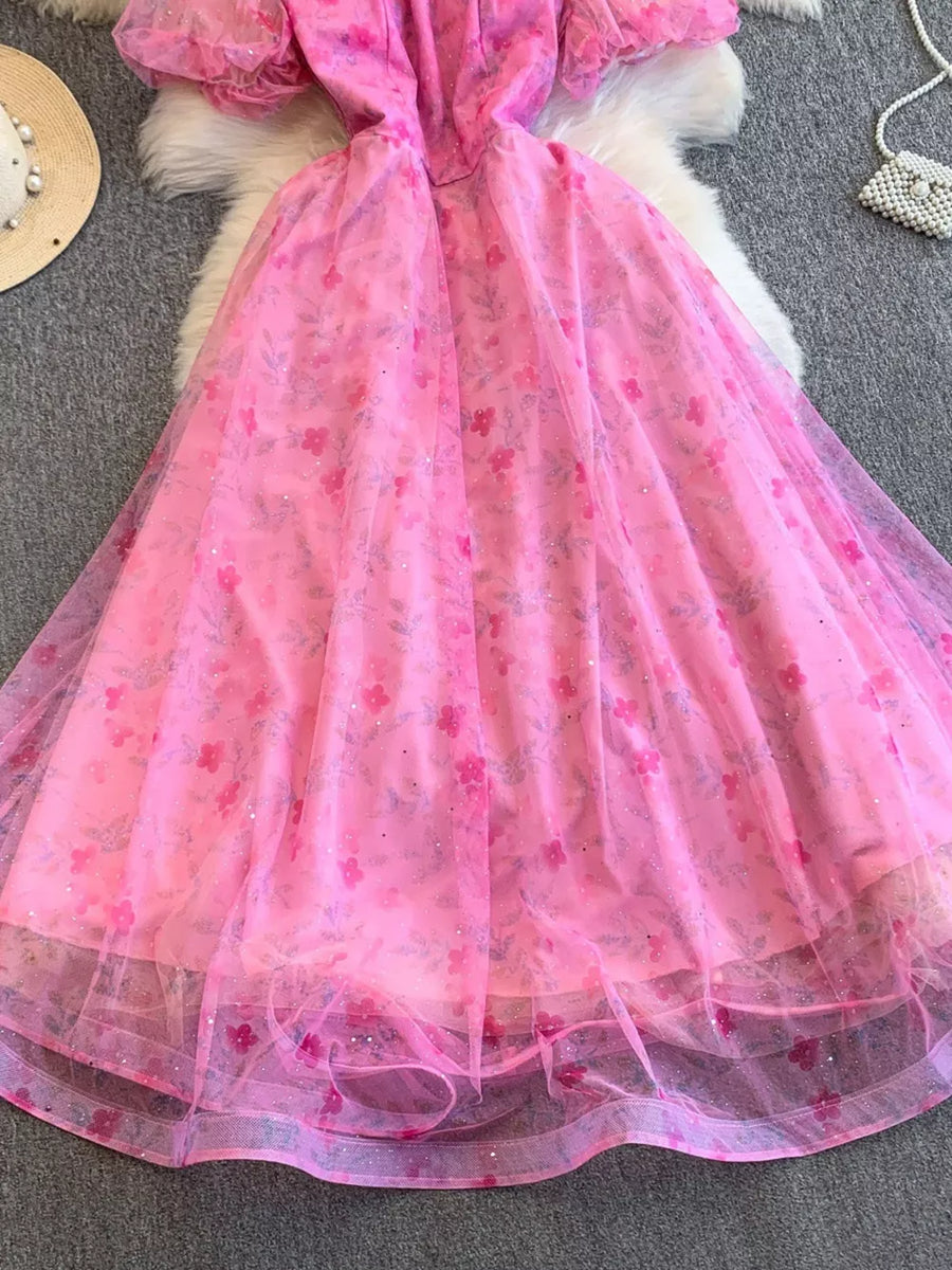 Pink floral maxi dress with puff sleeves and a sweetheart neckline, featuring lace embellishments.