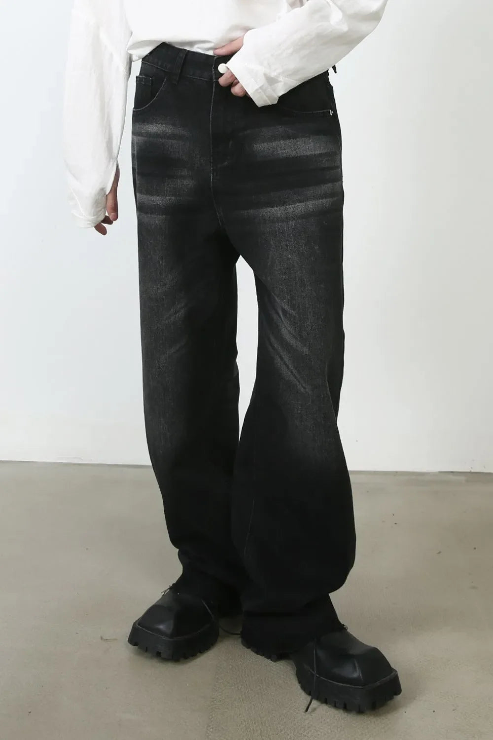 Dark wash denim barrel leg jeans with a sculpted fit and cat's whisker detail.