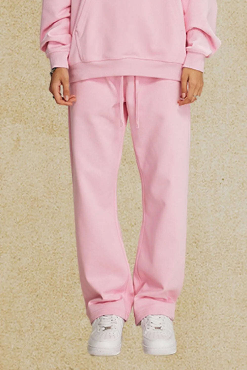 Blush pink relaxed fit lounge trousers with drawstring waist and cuffed ankles.