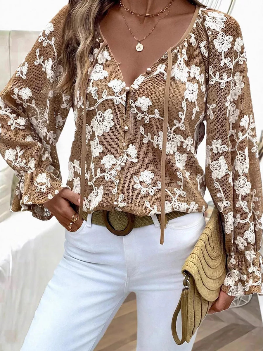 Coffee brown sheer blouse with white floral embroidery, tie neck, and button front.