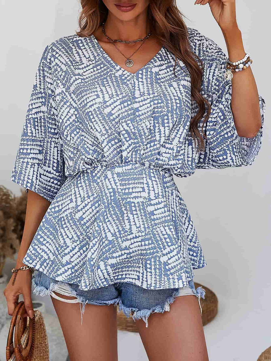 Light blue abstract print cinched waist blouse with V-neck and short sleeves.