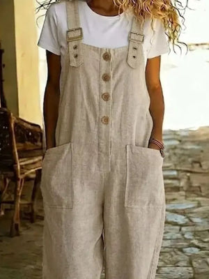 Rustic-button wide leg romper in beige with pockets and adjustable straps, worn over a white tee.
