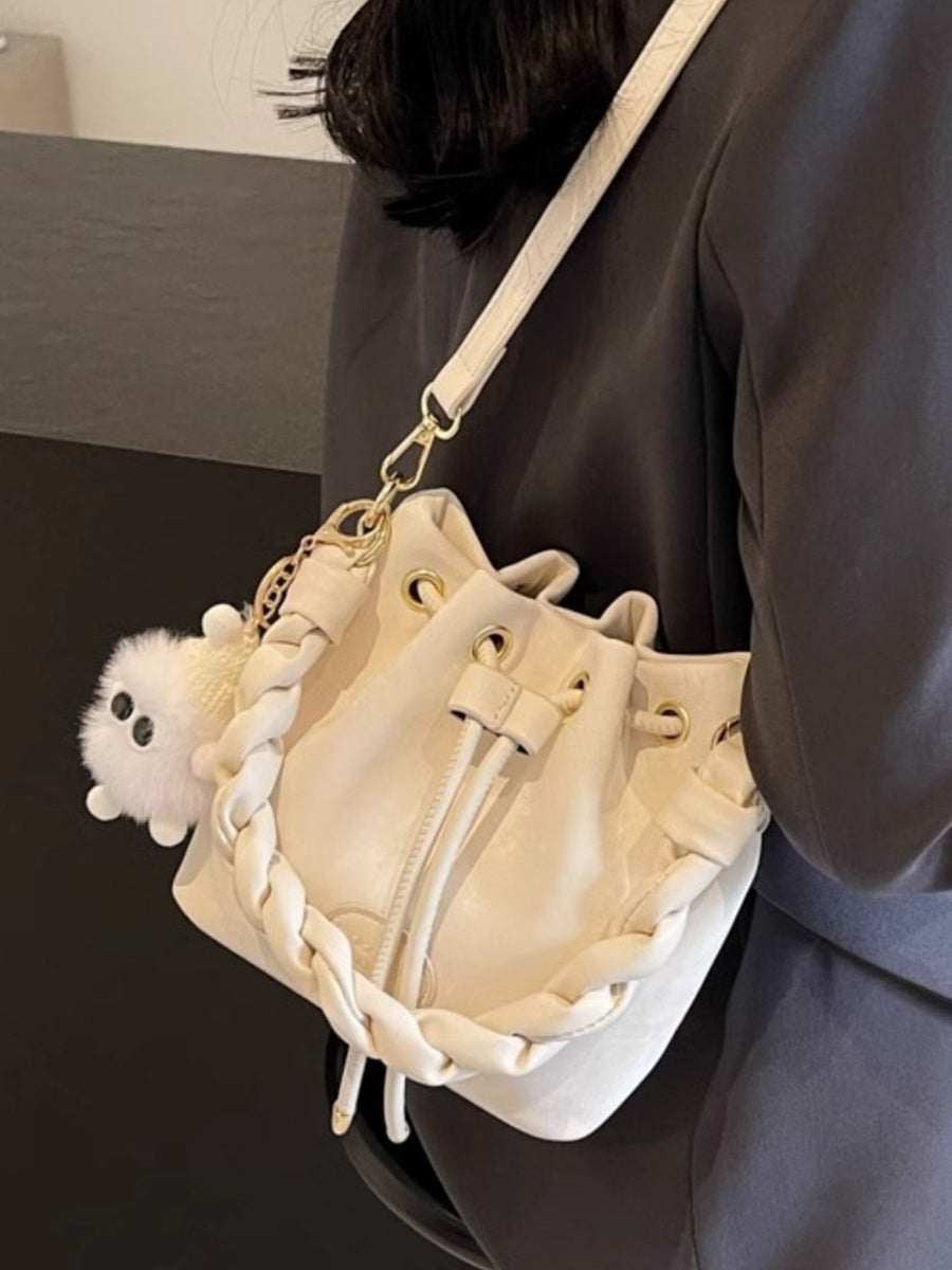 White bucket bag with chunky chain trim and fluffy charm