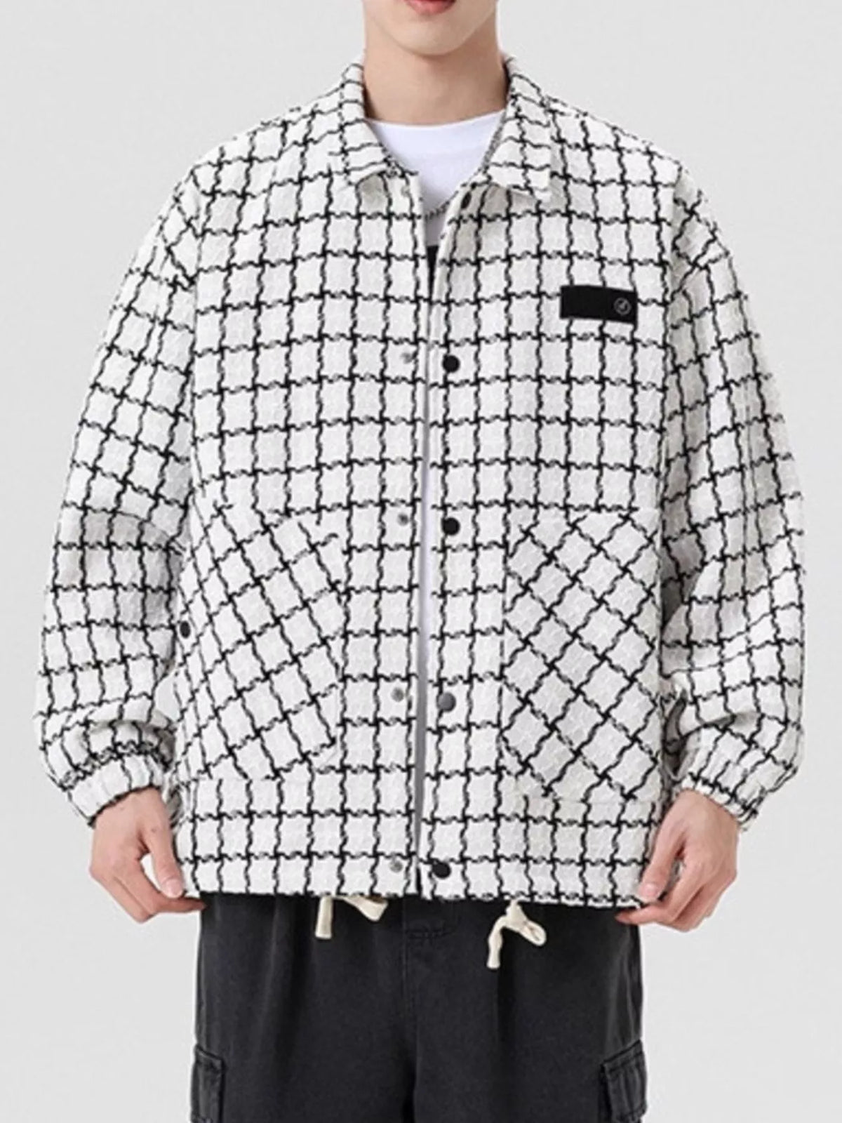 Oversized white plaid button-up jacket with black grid pattern and chest pocket detail.