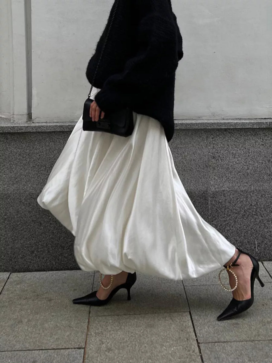 White voluminous midi skirt with black pointed-toe heels featuring pearl ankle straps.