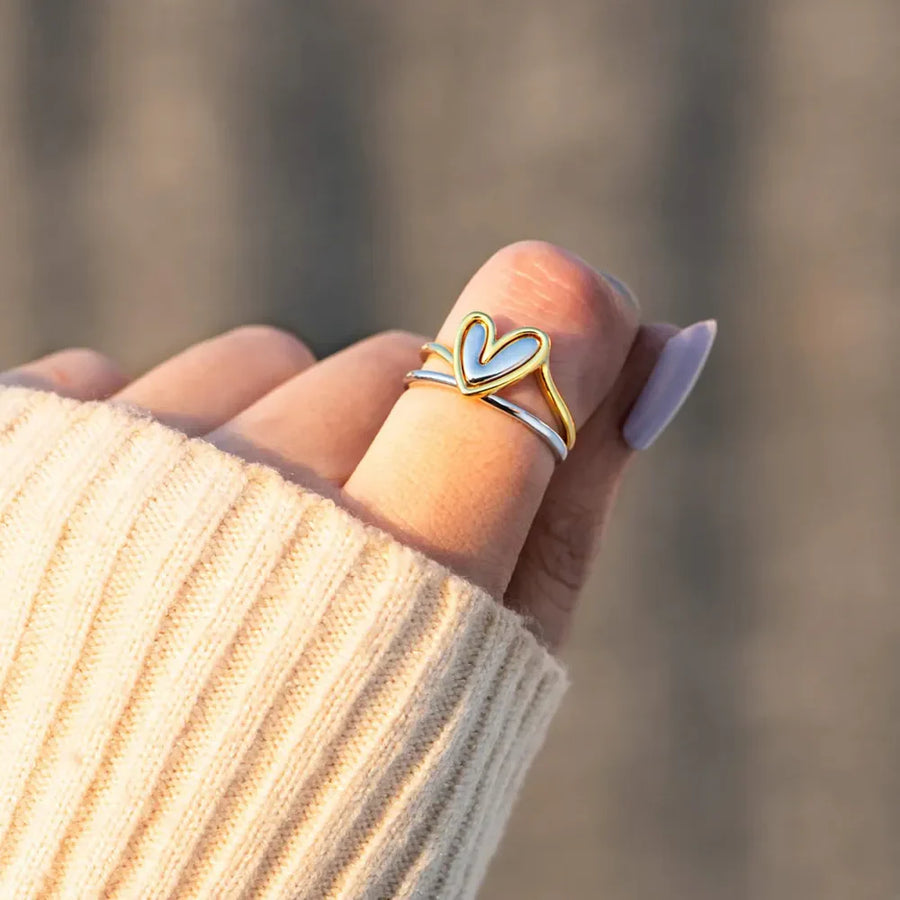 Two-tone gold and silver ring with a heart outline detail.