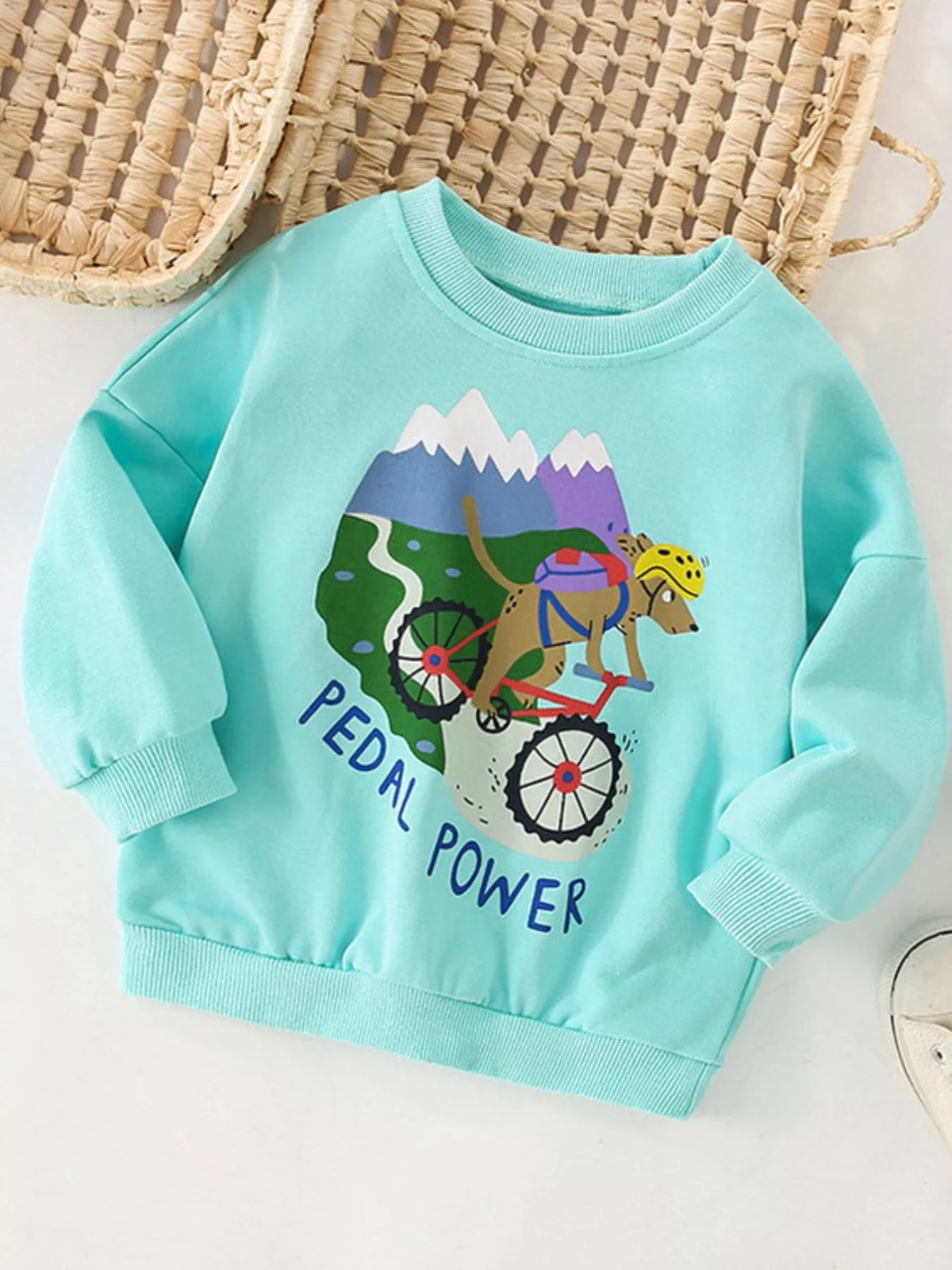 Kids' graphic sweatshirt in mint blue with a dog on a bike and "Pedal Power" text.
