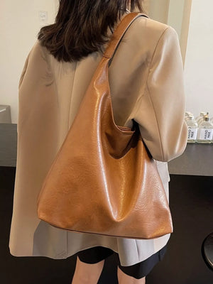 Sculptural PU leather tote bag in coffee color with a slouchy, unstructured design.
