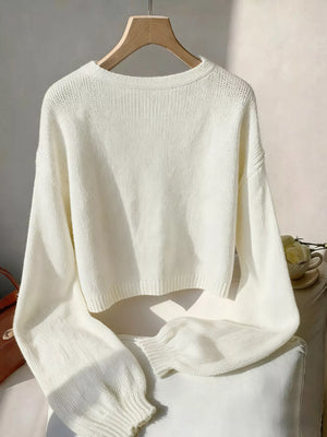 Beige acrylic knit cardigan with V-neck and bow embellishment.