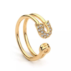 Gold double band ring with zircon-embellished safety pin detail