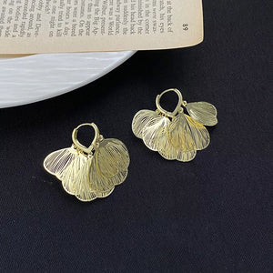 Gold earrings featuring textured and textured