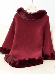 Burgundy knit poncho with faux fur trim at neckline and hem.