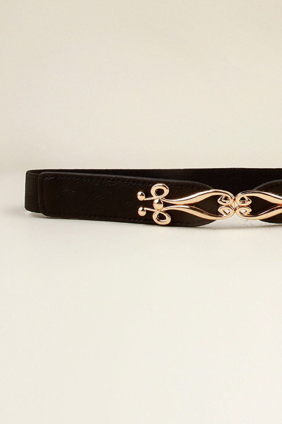 Black elastic belt with a sculpted gold alloy clasp.