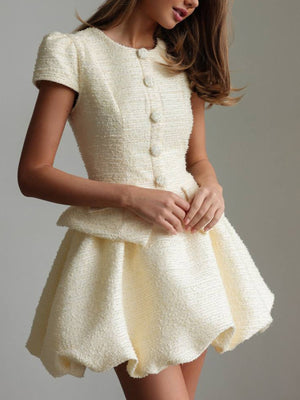 Textured cream button-down dress with short sleeves, peplum waist, and bubble hem skirt.