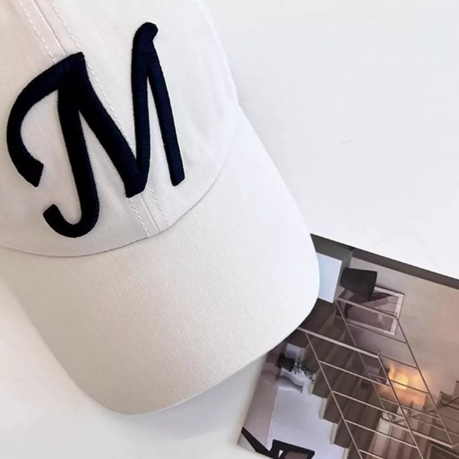 Off-white baseball cap with embroidered navy blue M detail