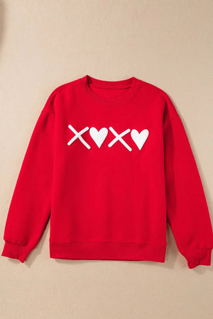 Red crewneck sweatshirt with white XOXO graphic print and ribbed cuffs and hem.