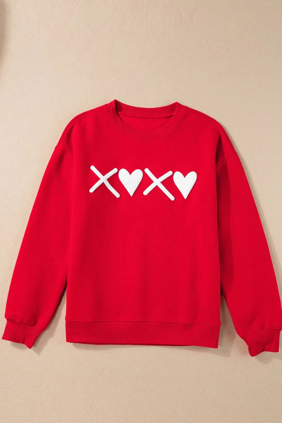 Red crewneck sweatshirt with white XOXO graphic print and ribbed cuffs and hem.