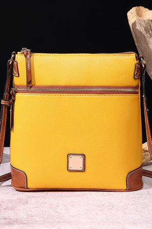 Yellow leather crossbody bag with brown trim and two zippered compartments.