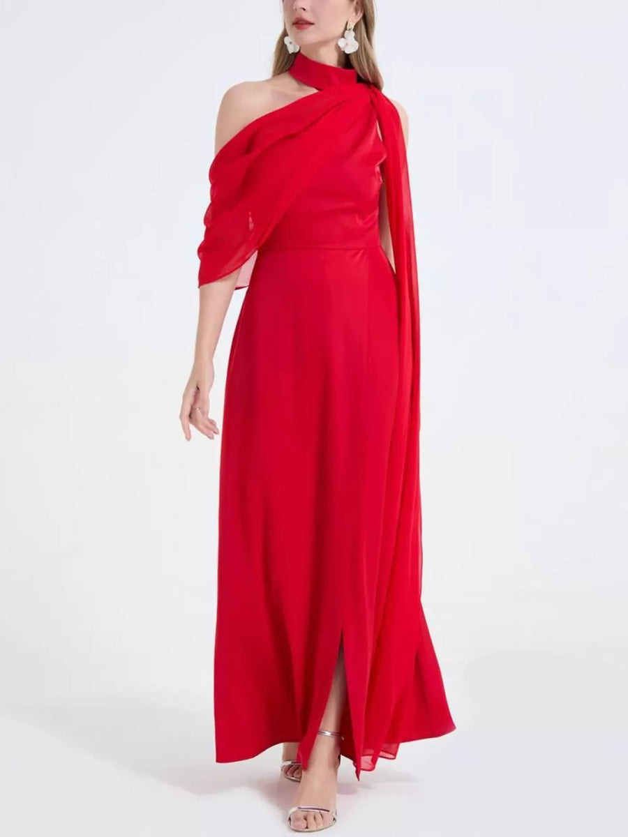 Red asymmetrical maxi dress with high slit and draped neckline, brocade fabric.