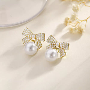 Gold bowknot pearl drop earrings with 18K gold plating.