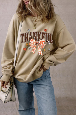 Khaki graphic sweatshirt with "Thankful" text and a leopard print bow detail.