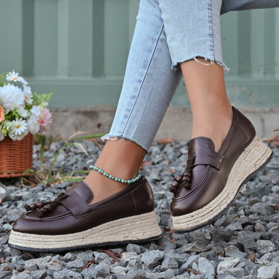 Brown espadrille wedge slip-on loafers with tassel detail and braided jute sole.