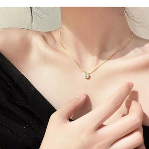 Gold box chain necklace with a single round zircon pendant.