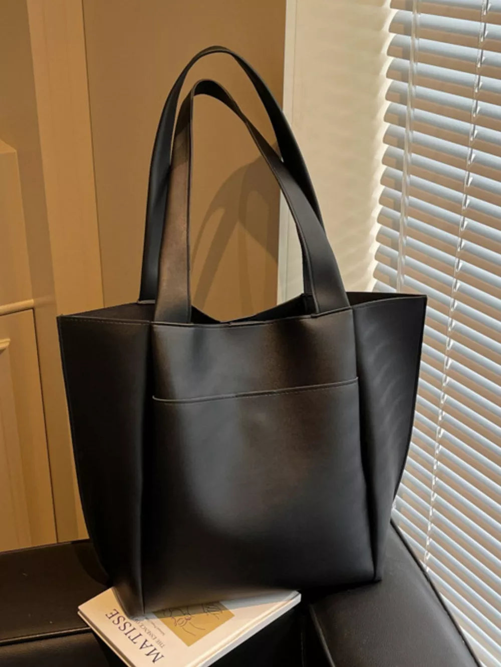 Black pu leather tote bag with front pocket and double shoulder straps.