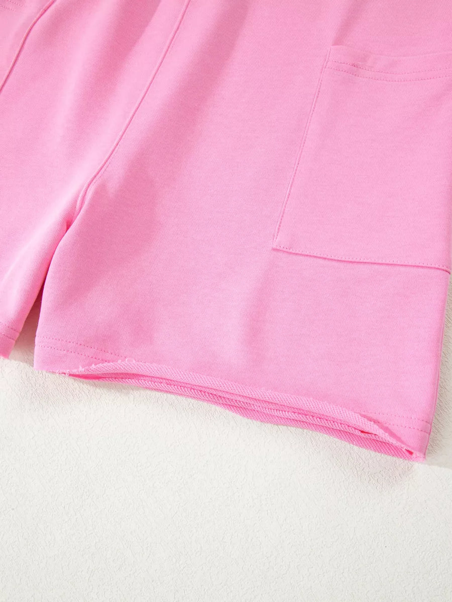 Pink cotton romper shorts with pocket detail and raw hem.