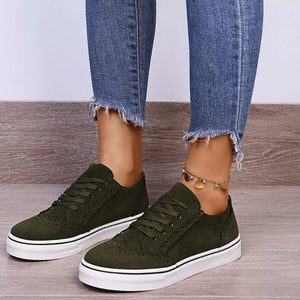 Green matte finish lace-up sneakers with white soles and brogue detailing.