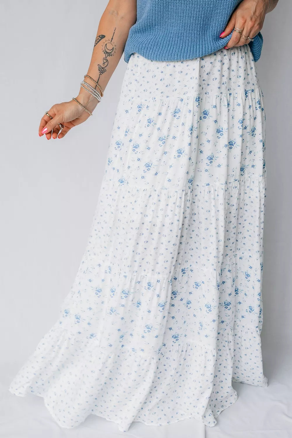 Bohemian tiered maxi skirt with a blue floral print on white fabric.