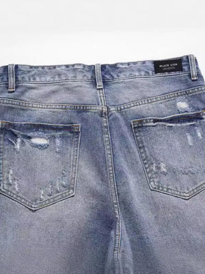 Ripped denim bermuda shorts in medium wash with distressed details and back pockets.