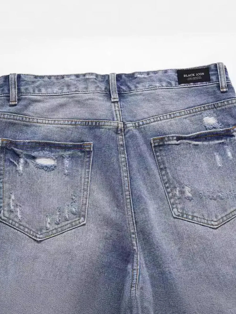 Ripped denim bermuda shorts in medium wash with distressed details and back pockets.