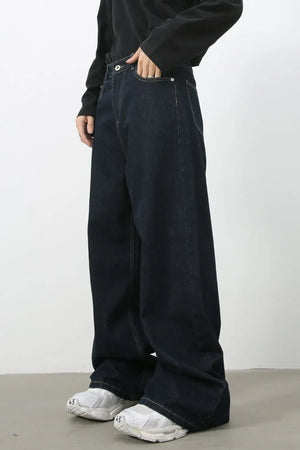 Dark wash denim trousers with exaggerated wide legs and a casual fit.