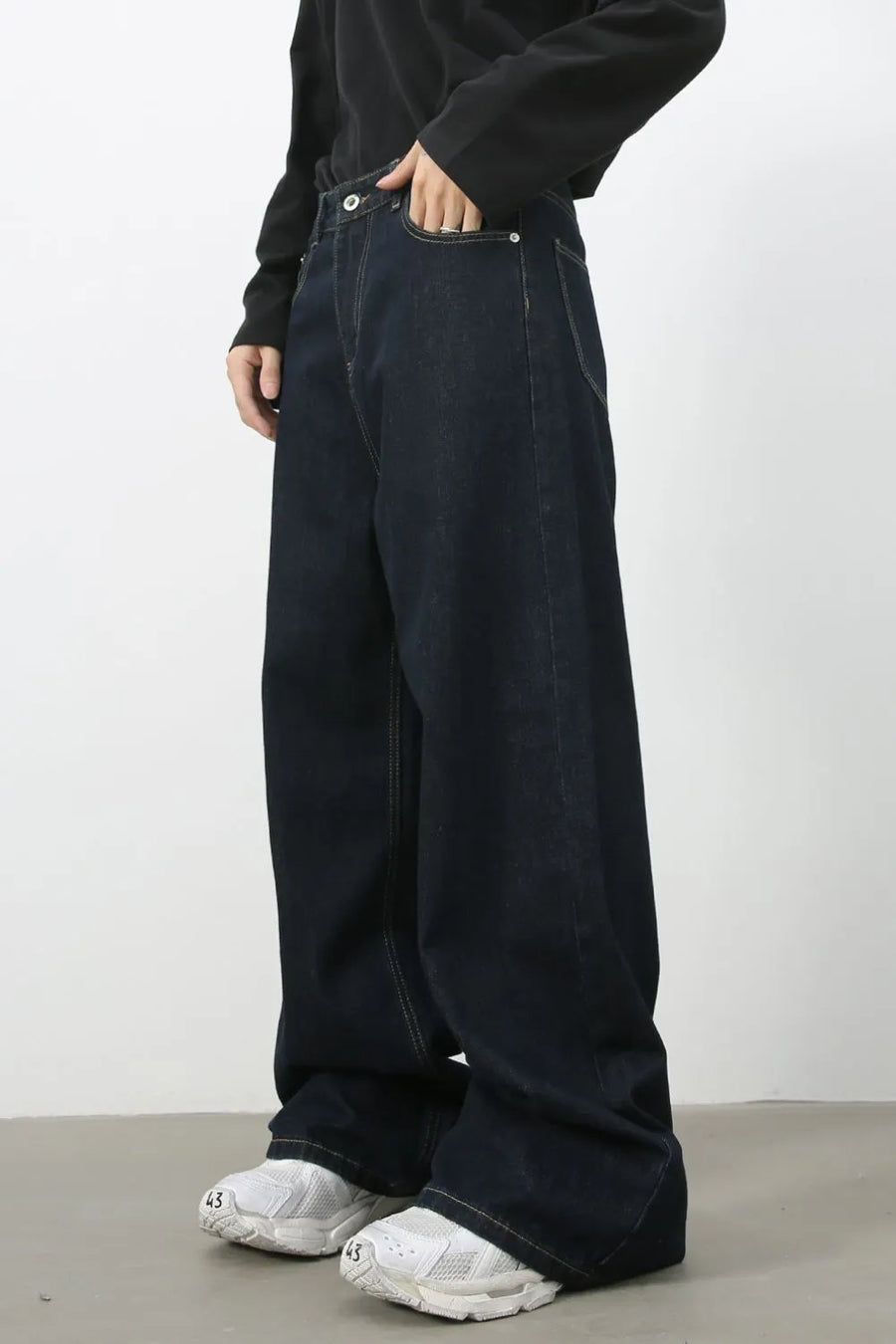 Dark wash denim trousers with exaggerated wide legs and a casual fit.