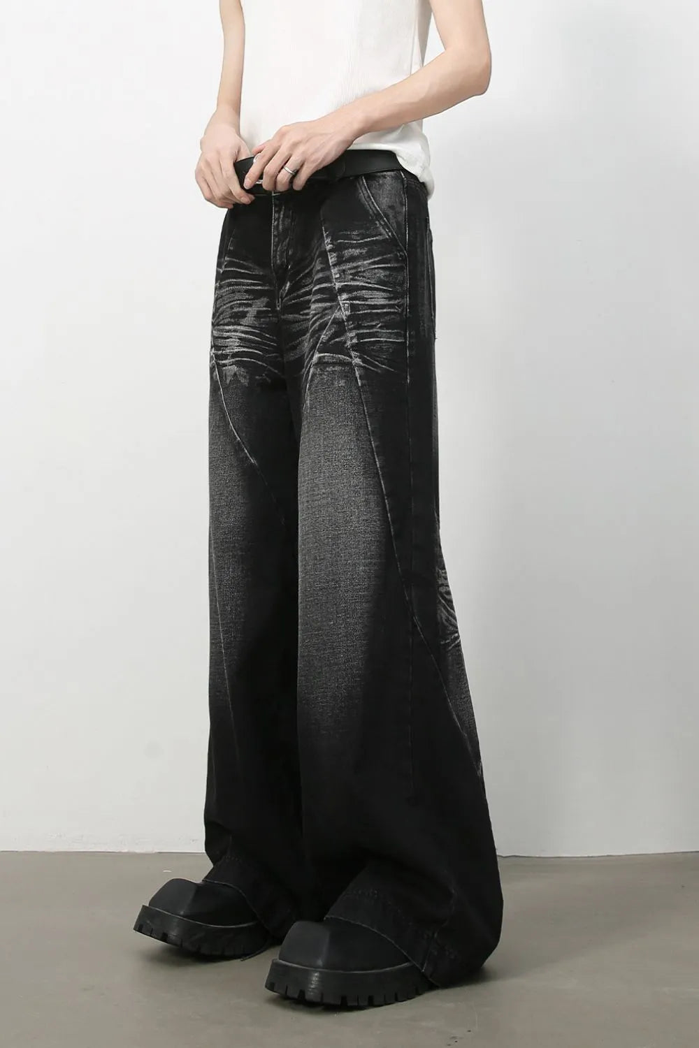 Dark wash wide leg jeans with sculpted details and a faded cat's whisker pattern.