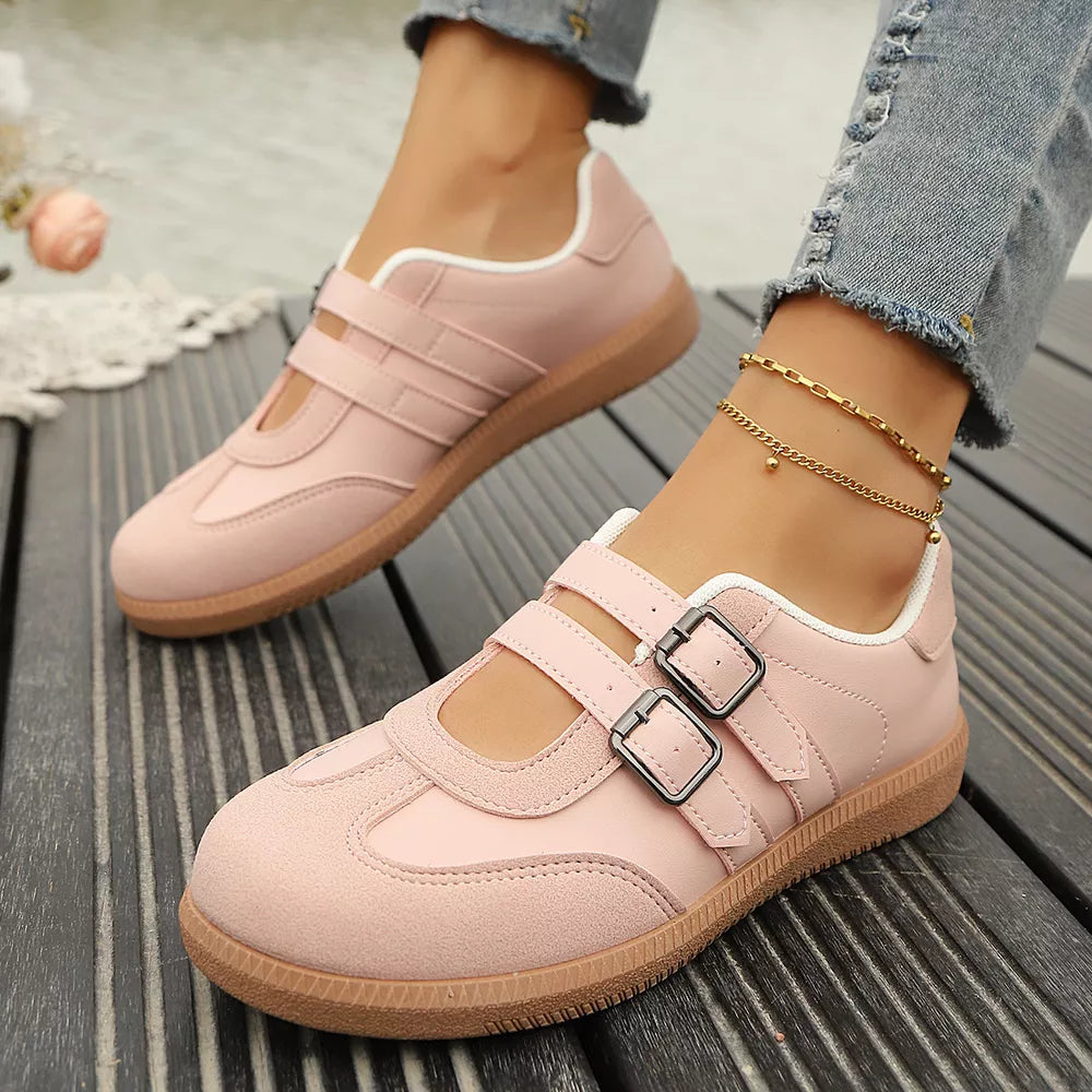 Pink buckle strap Mary Jane inspired sneakers with white trim and brown soles.