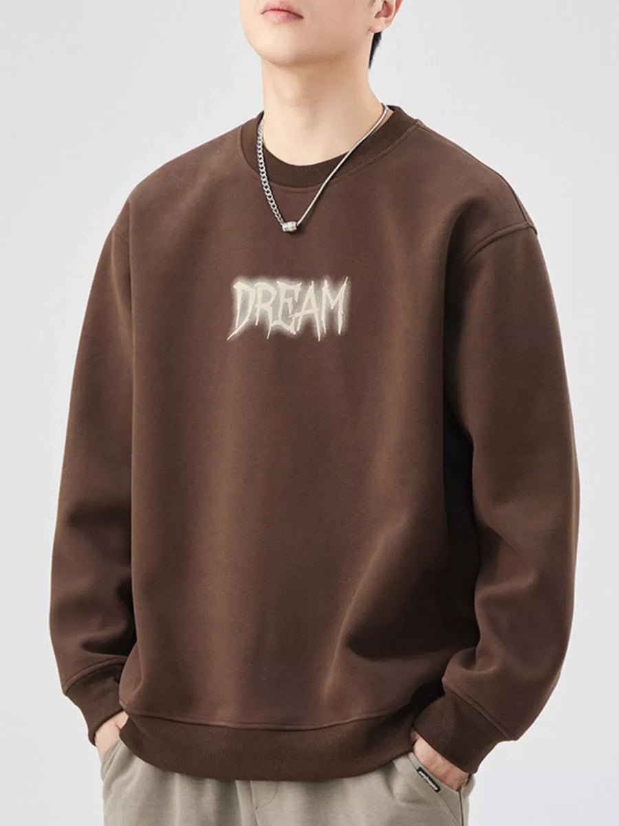 Brown oversized crew-neck sweatshirt with "DREAM" graphic detail and ribbed cuffs.
