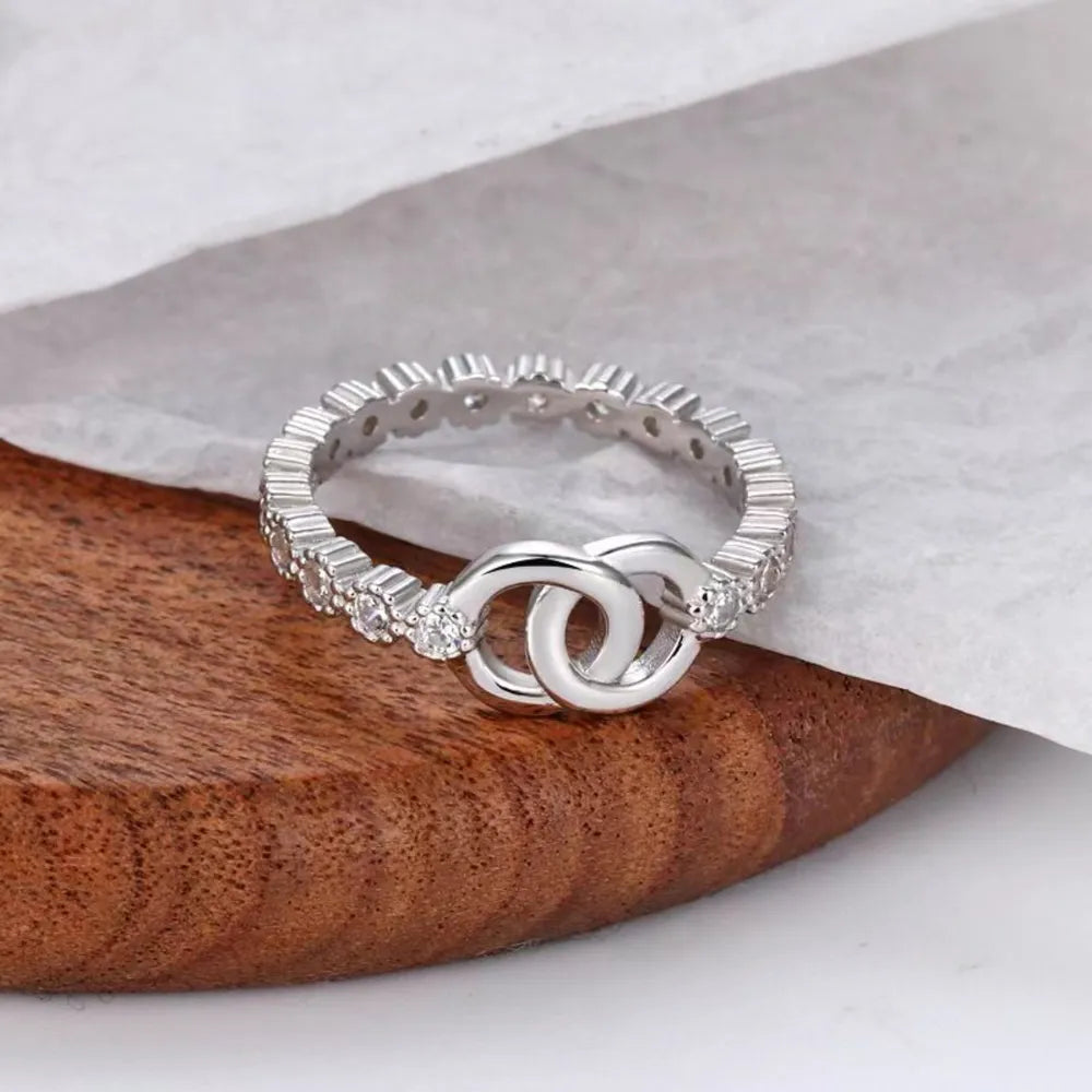 Silver pavé eternity ring with interlocking circles detail.