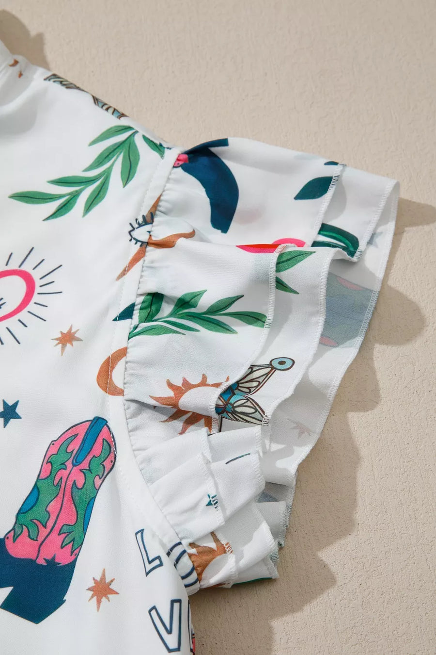 White polyester mini dress with Western print, flutter sleeves, and ruffled trim.