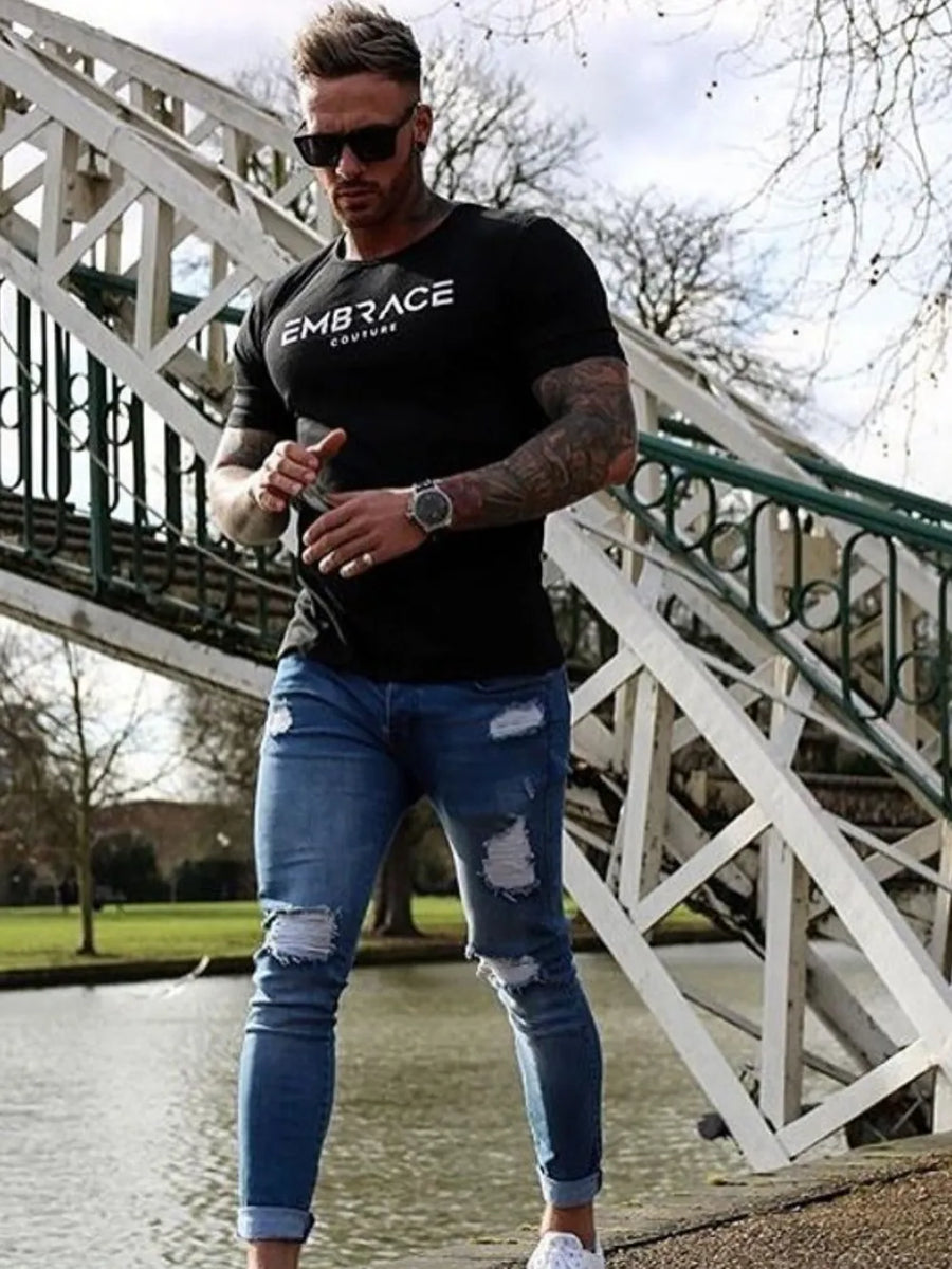 Black t-shirt with white Embrace Couture logo, crew neck, short sleeves.