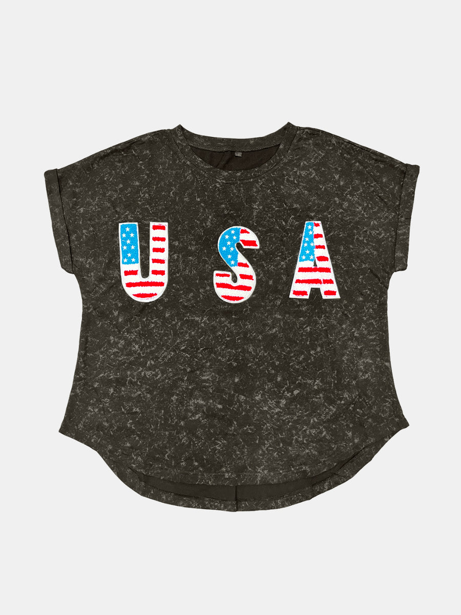 Black acid wash t-shirt with embroidered USA flag letters, cuffed short sleeves.