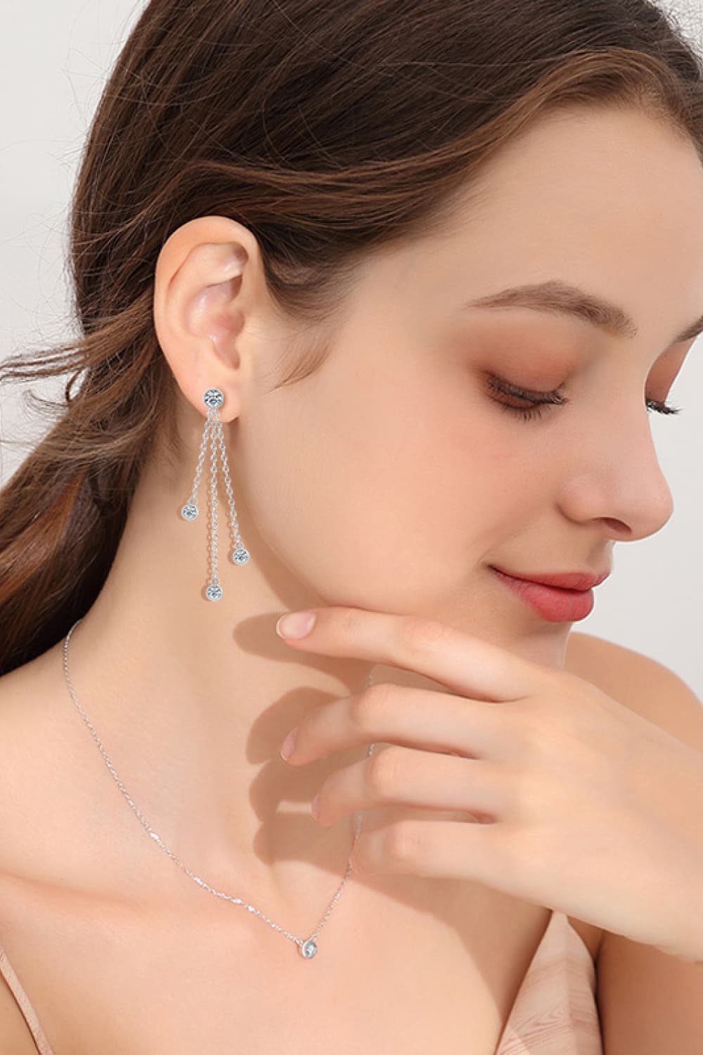 Cascading crystal chain drop earrings in silver with dangling clear stones.