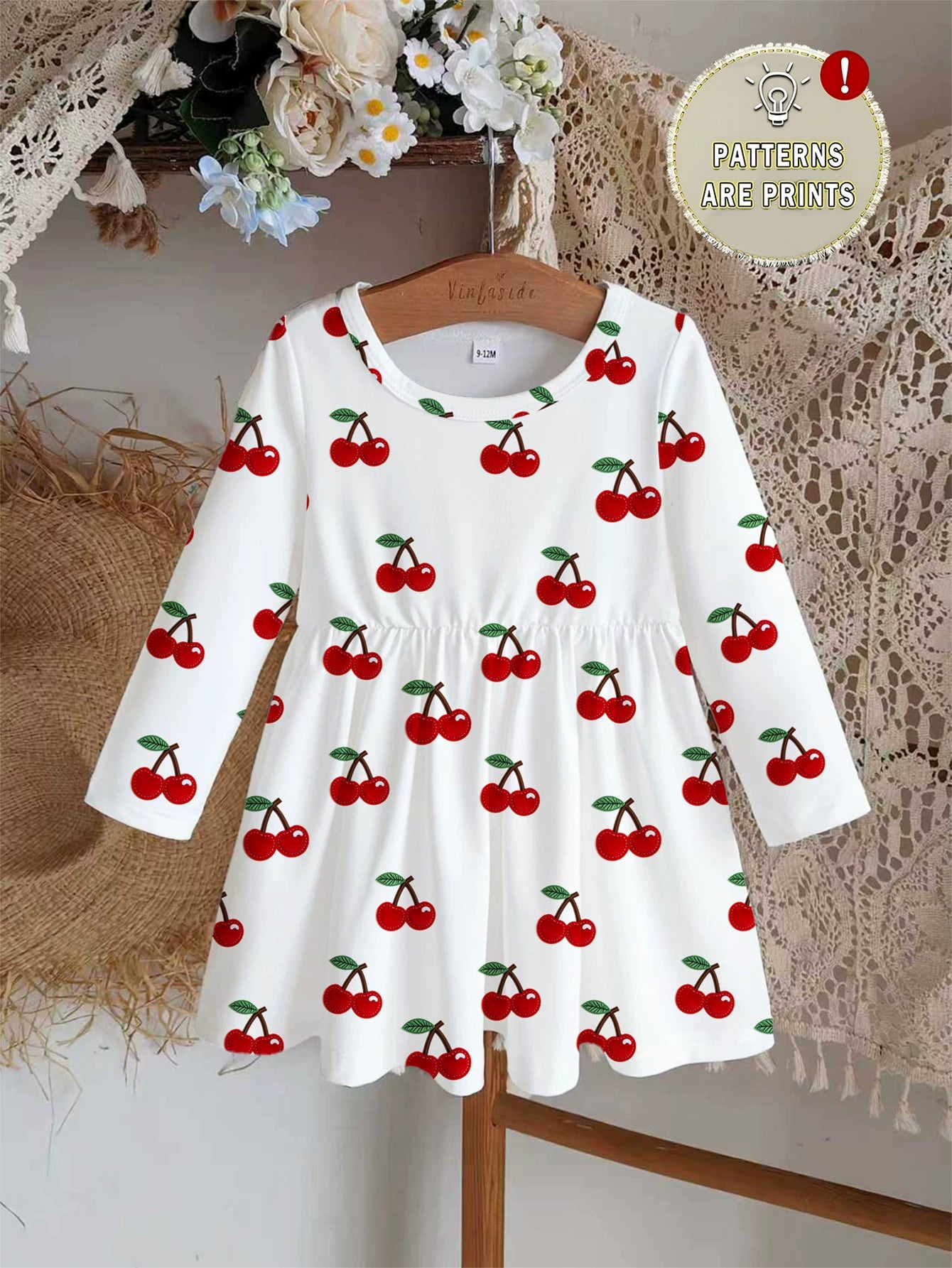 White long sleeve baby dress with allover red cherry print and gathered waist